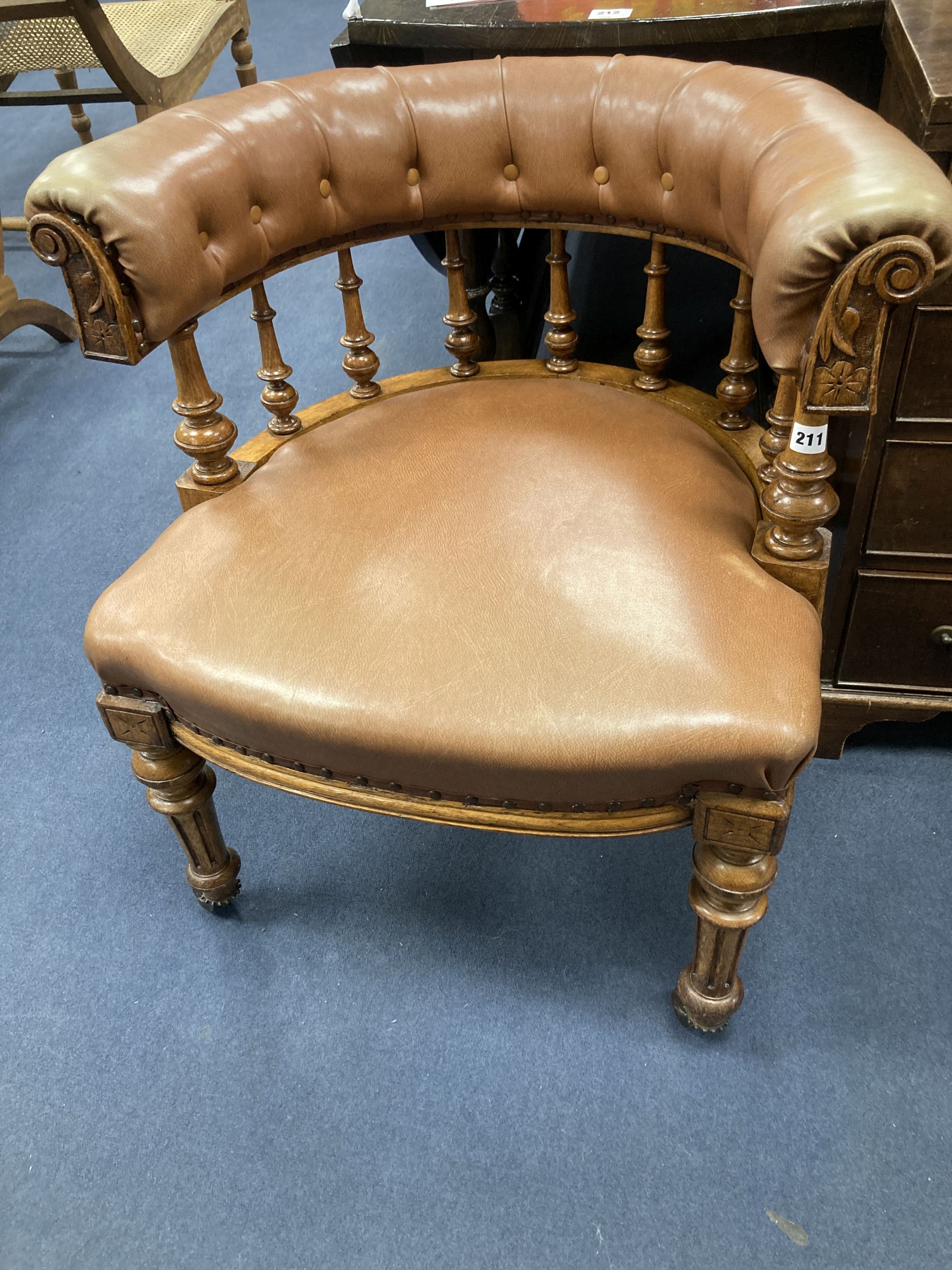 A Victorian oak tub framed library chair, upholstered in brown leather, width 60cm, depth 60cm, height 74cm